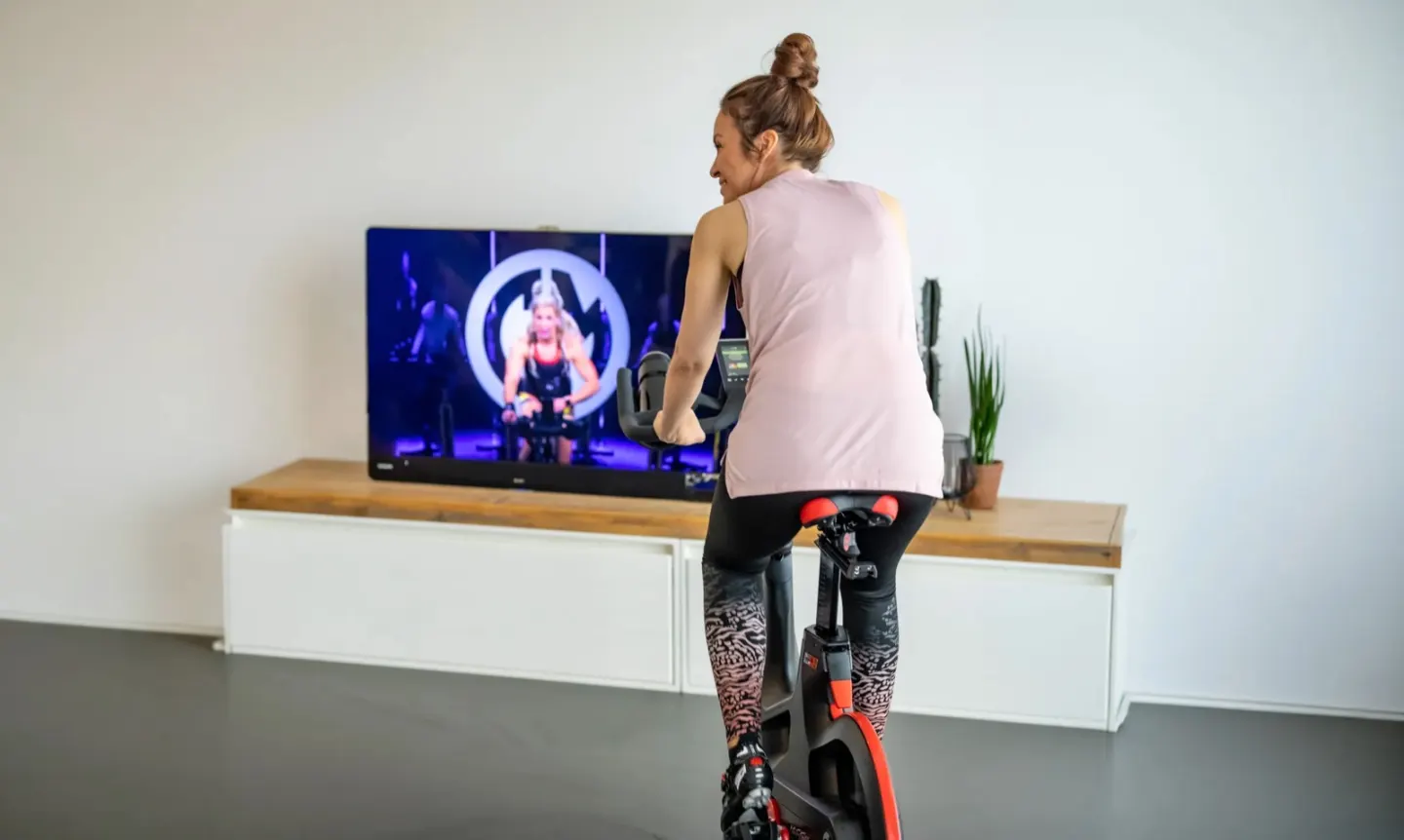Rider following a workout on TV, at home on the bike